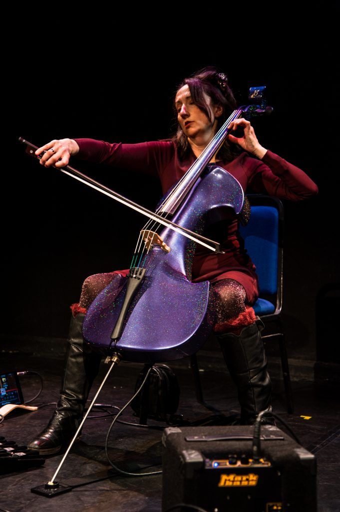 Jo-anne, seated, plays her sparkly purple electric cello.