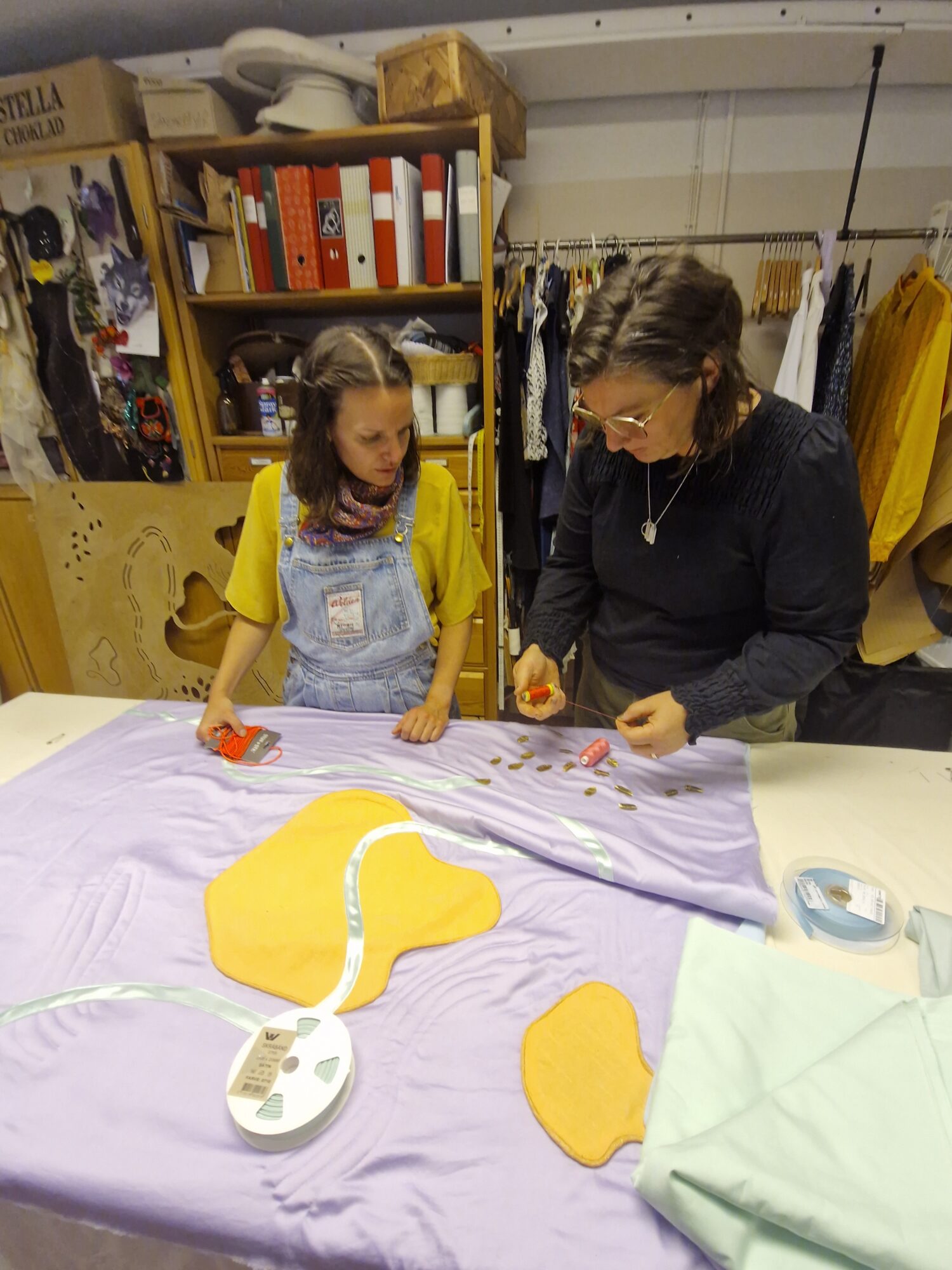 Two makers at a workshop table making a sensory blanket
